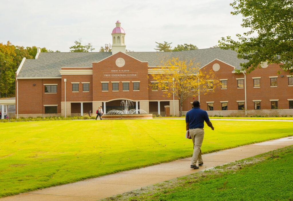 a man walking on a path in front of a building