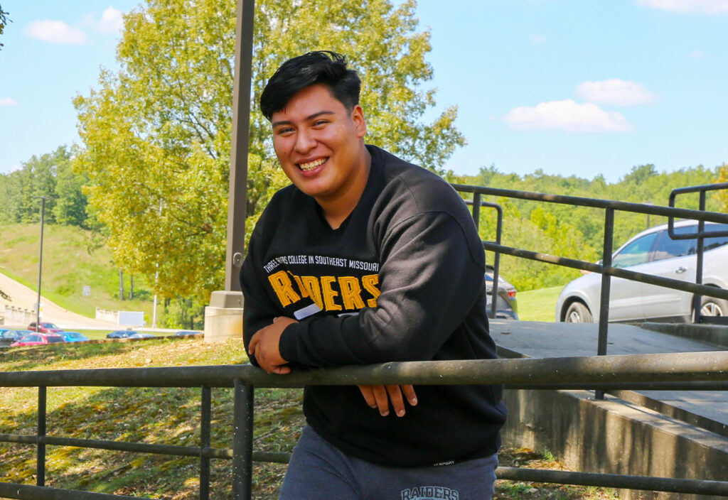 a man standing by a fence